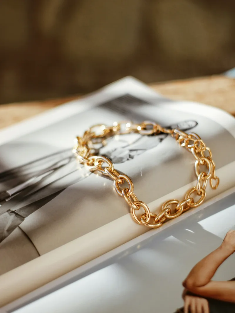 Gold chain bracelet styled on a magazine