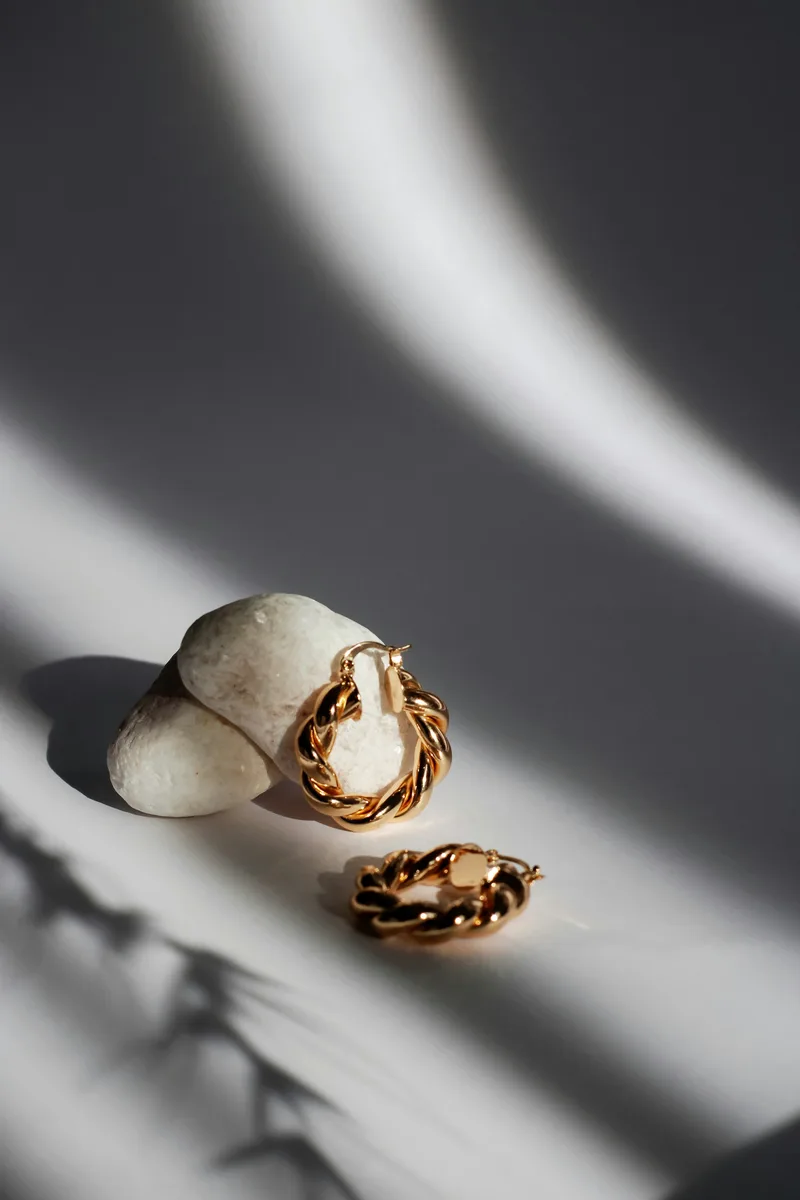 Gold hoop earrings in dramatic light
