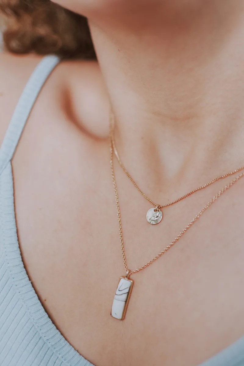 Model wearing layered necklaces